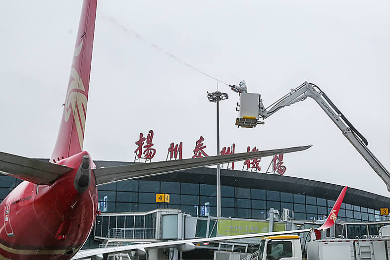 上图:雪中的武坚中学校园;左图:扬州泰州国际机场除雪现场.