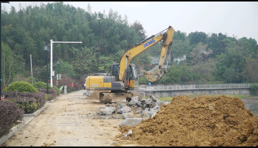 在東亭鄉東亭湖水庫除險加固施工現場,工人們正搶抓當前的晴好天氣